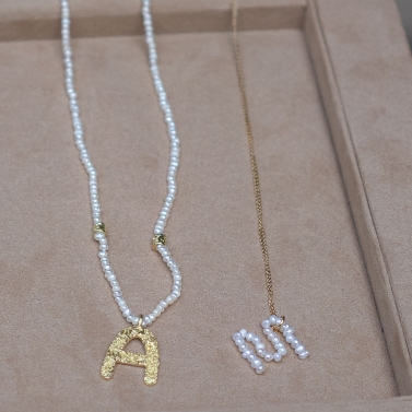 NOMS GOLD AND PEARL LETTER M NECKLACE